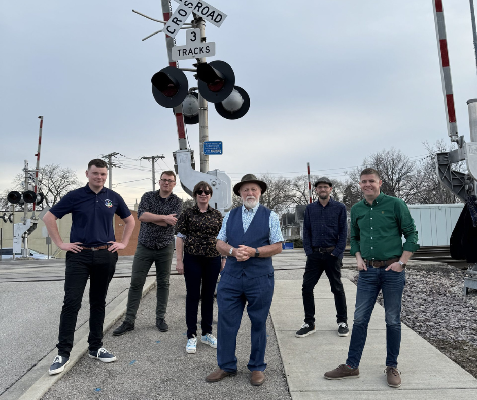 Derek Warfield & the Young Wolfe Tones standing in a street by a railroad crossing