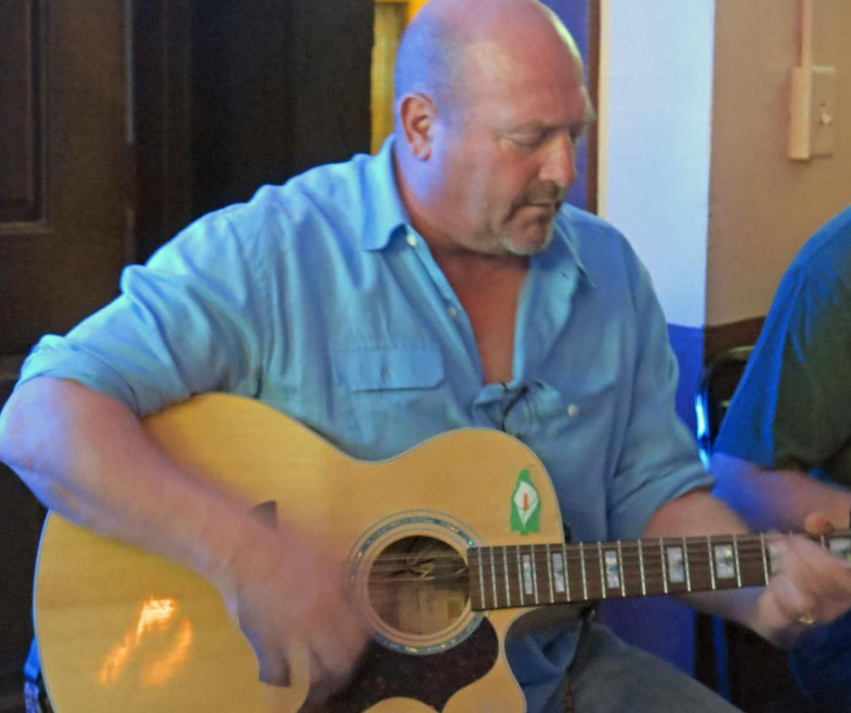 JTJ McDonagh sitting playing a guitar