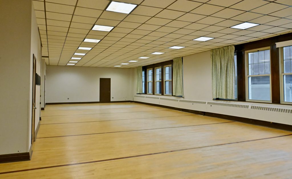 A picture of the a empty room with green curtains on the windows