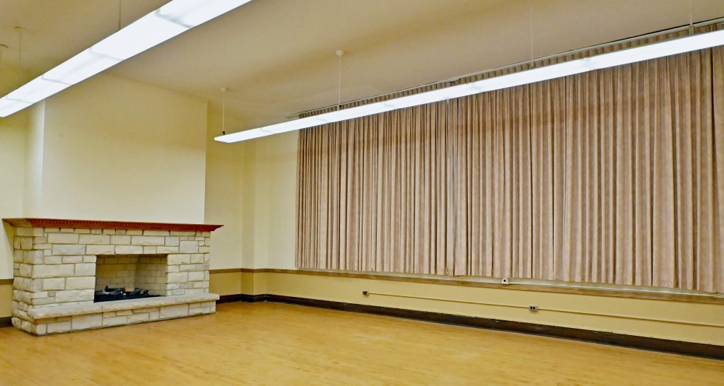 Picture of the room with a bricked chimney with the curtains closed