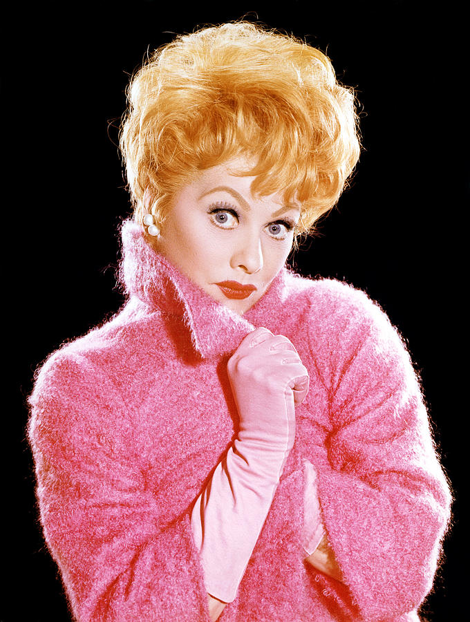 A picture of a lady with blond hair wearing a pink coat with pink gloves